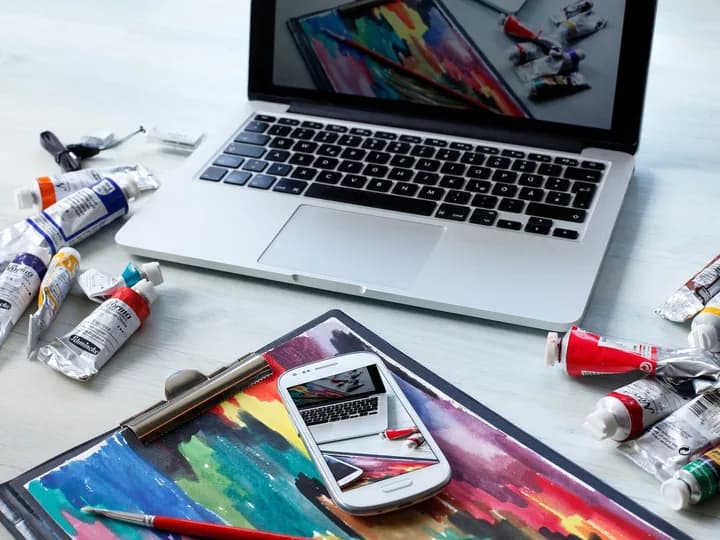 Refonte graphique et expérience utilisateur Un ordinateur et une tablette entourés de matériel de création graphique