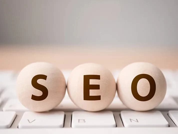 Référencement naturel et visibilité de votre site Les lettres SEO sur des cubes en bois devant une plante